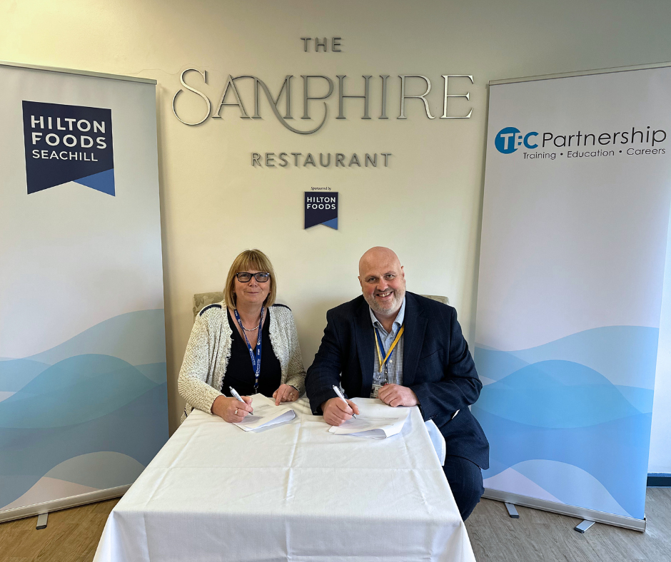 Ann Hardy, CEO of TEC Partnership, and Chris Hayes, Managing Director of Hilton Foods Seachill, sign agreement in the Samphire Restaurant.